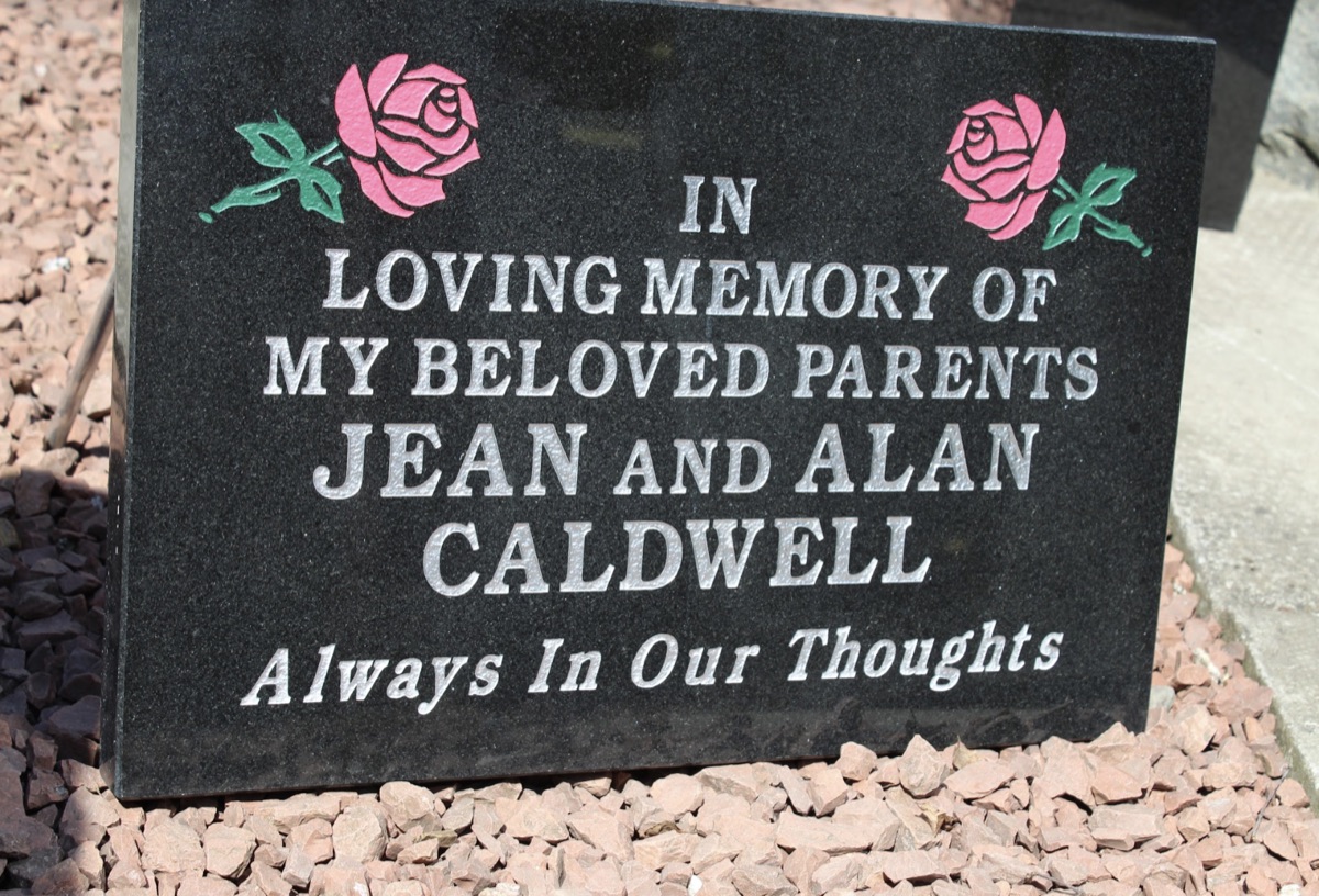 Black granite memorial plaque with silver lettering and painted roses