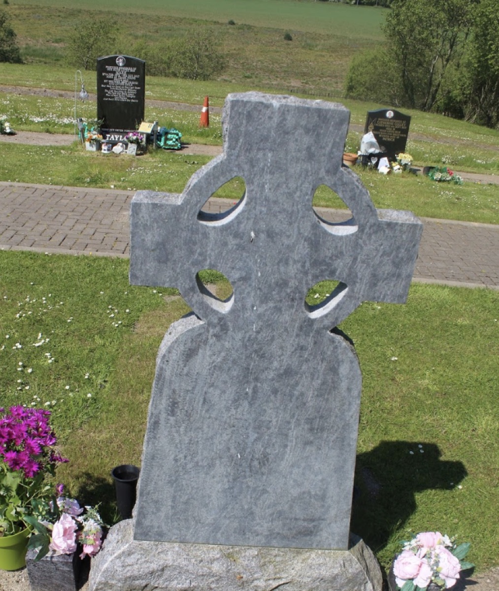 Carved granite Celtic cross headstone in a Scottish cemetery