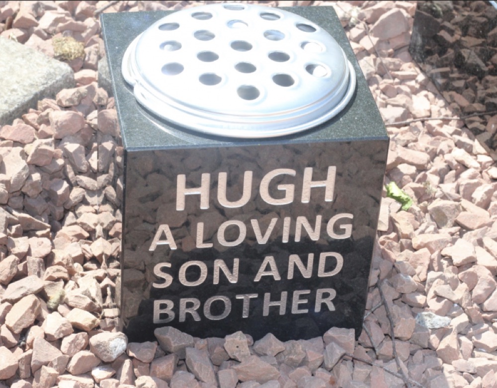 Black granite memorial flower vase with an engraved inscription