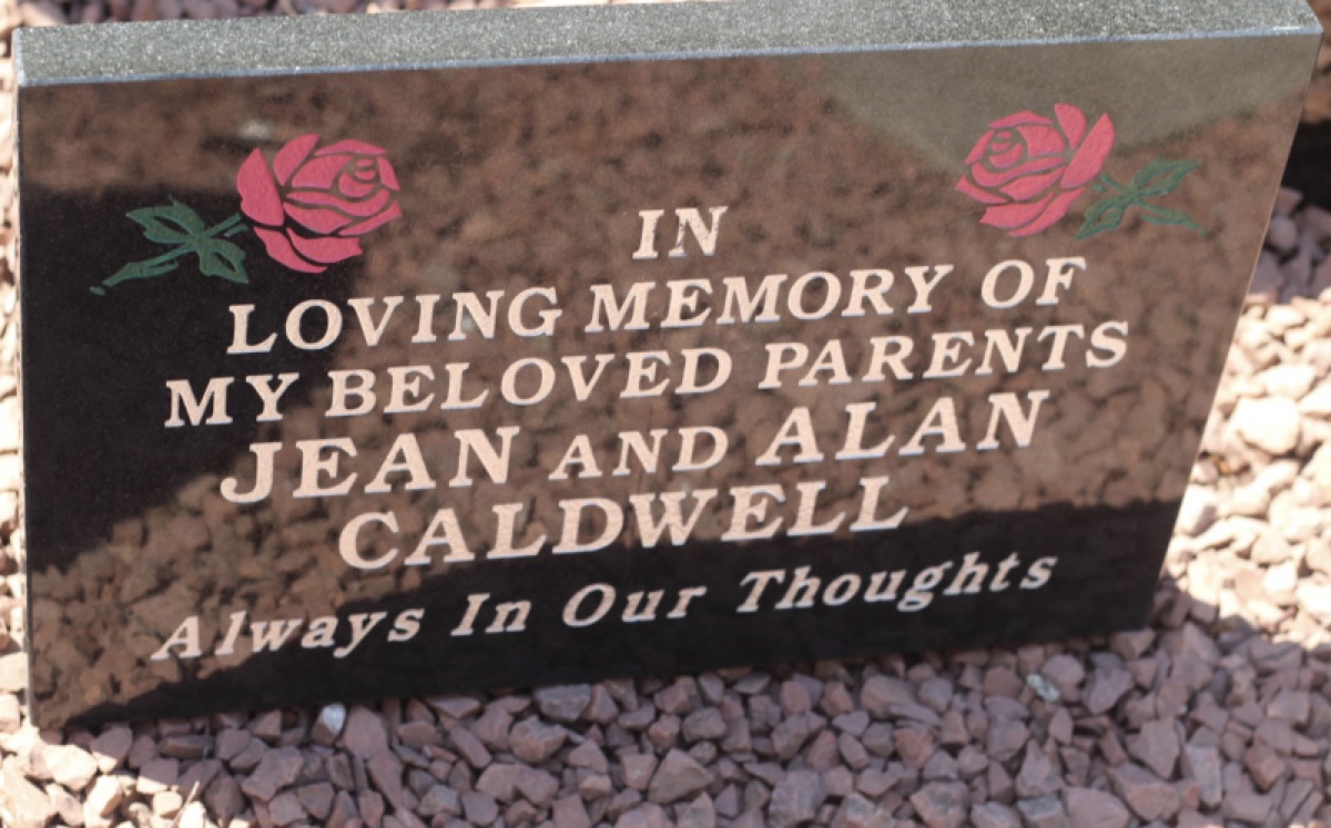 Black granite lawn plaque with gilt inscription and carved roses